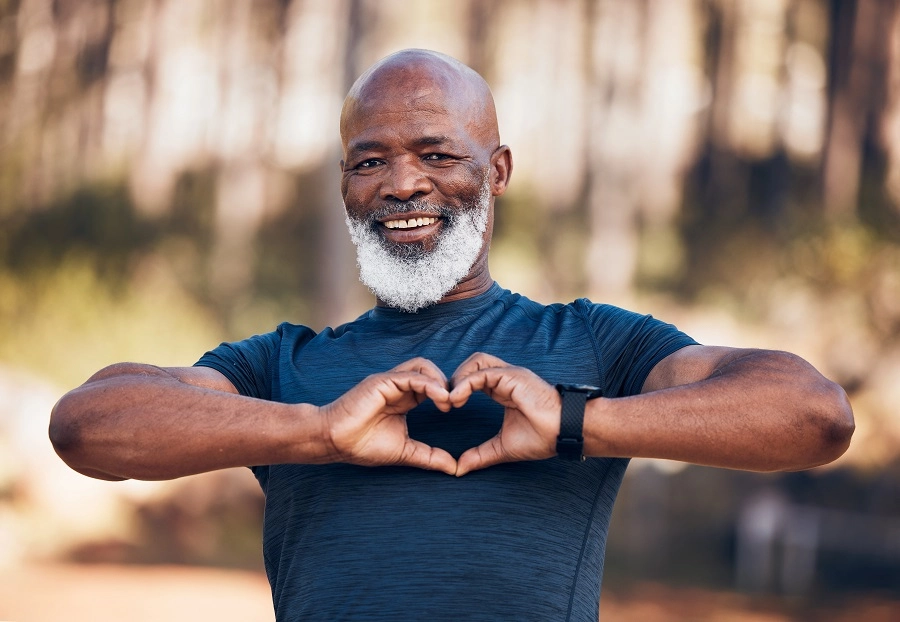 Smiling older man making a heart shape with his hands