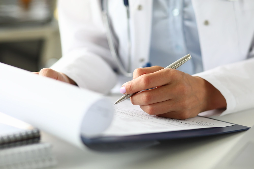 Doctor writing on a clipboard
