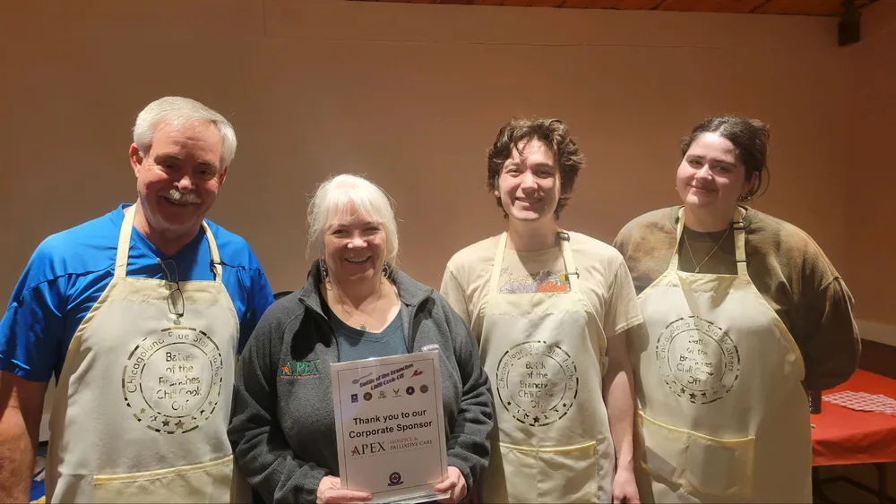 Voluntarios de APEX con delantales en un concurso de chili.