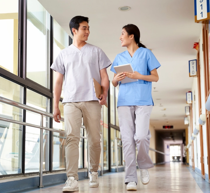 Two nurses walking and talking in a hospital corridor