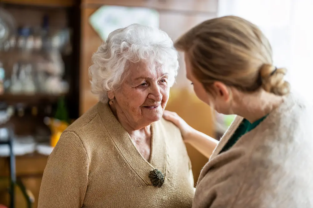 Caregiver talking with a smiling older woman