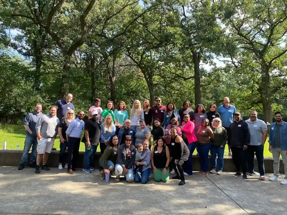APEX team group photo outdoors in front of trees