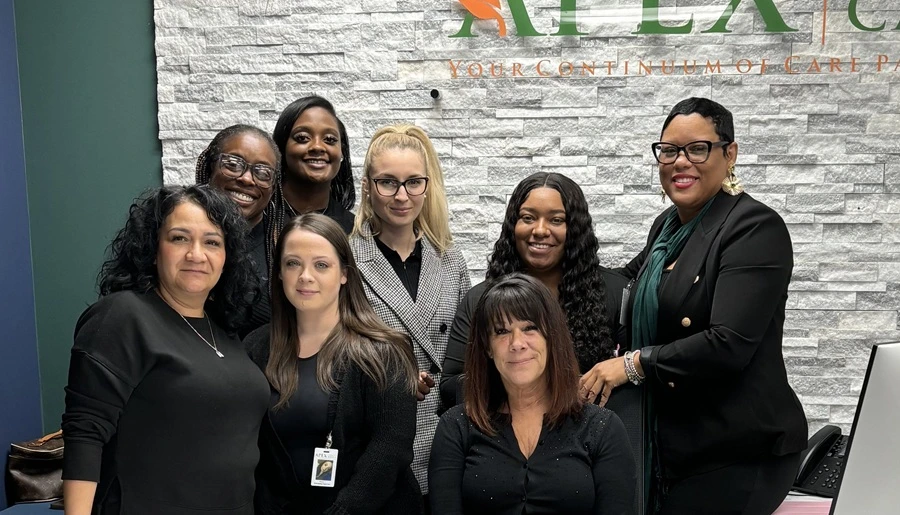 APEX office team photo in front of the company sign