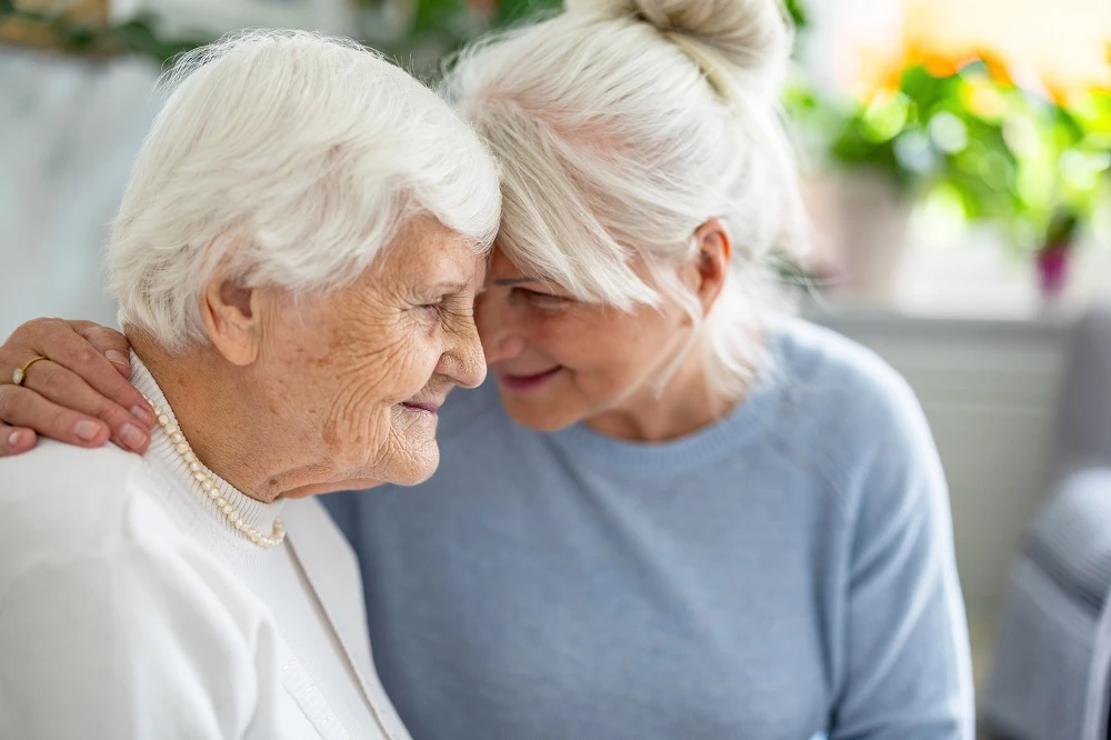 Dos mujeres mayores apoyando sus cabezas juntas